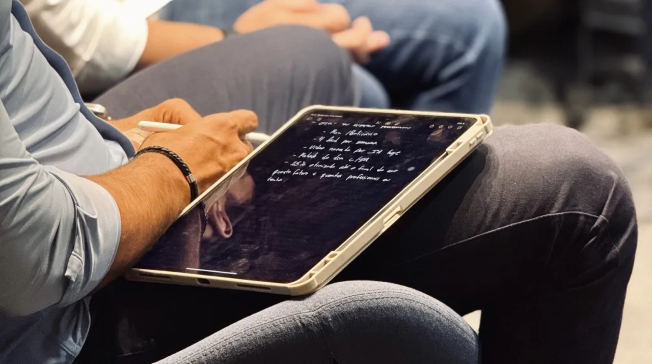 Profissional anotando plano de dados em tablet durante reunião