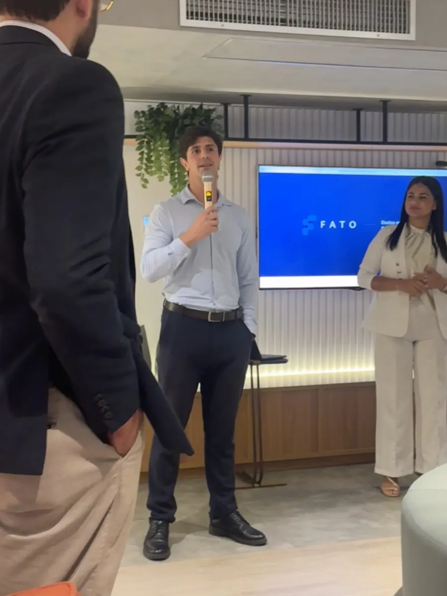 Abertura de um encontro presencial da Fato Analytics, com a marca projetada na tela ao fundo
